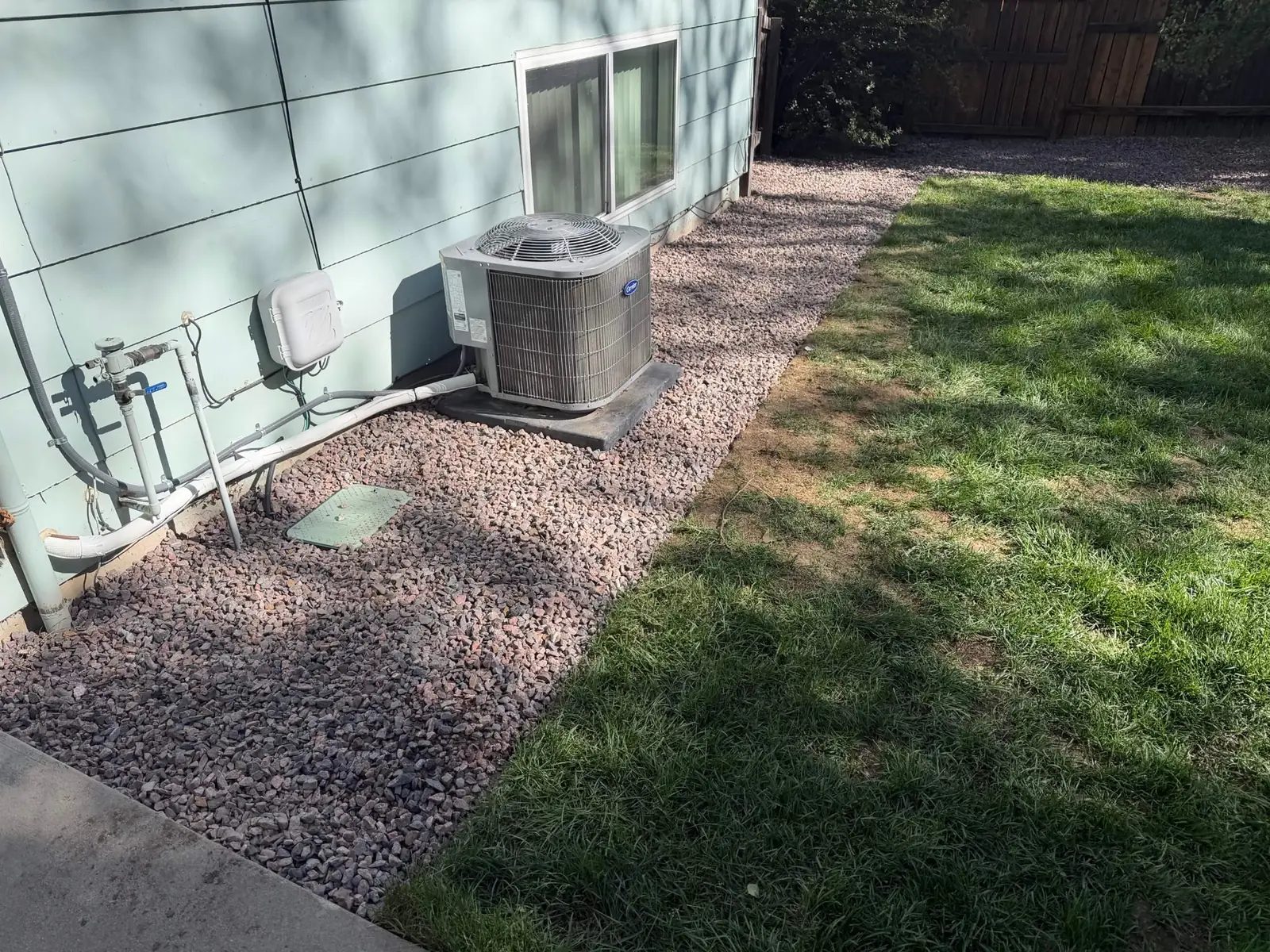 Decorative rock landscape bed installed around an outdoor HVAC unit