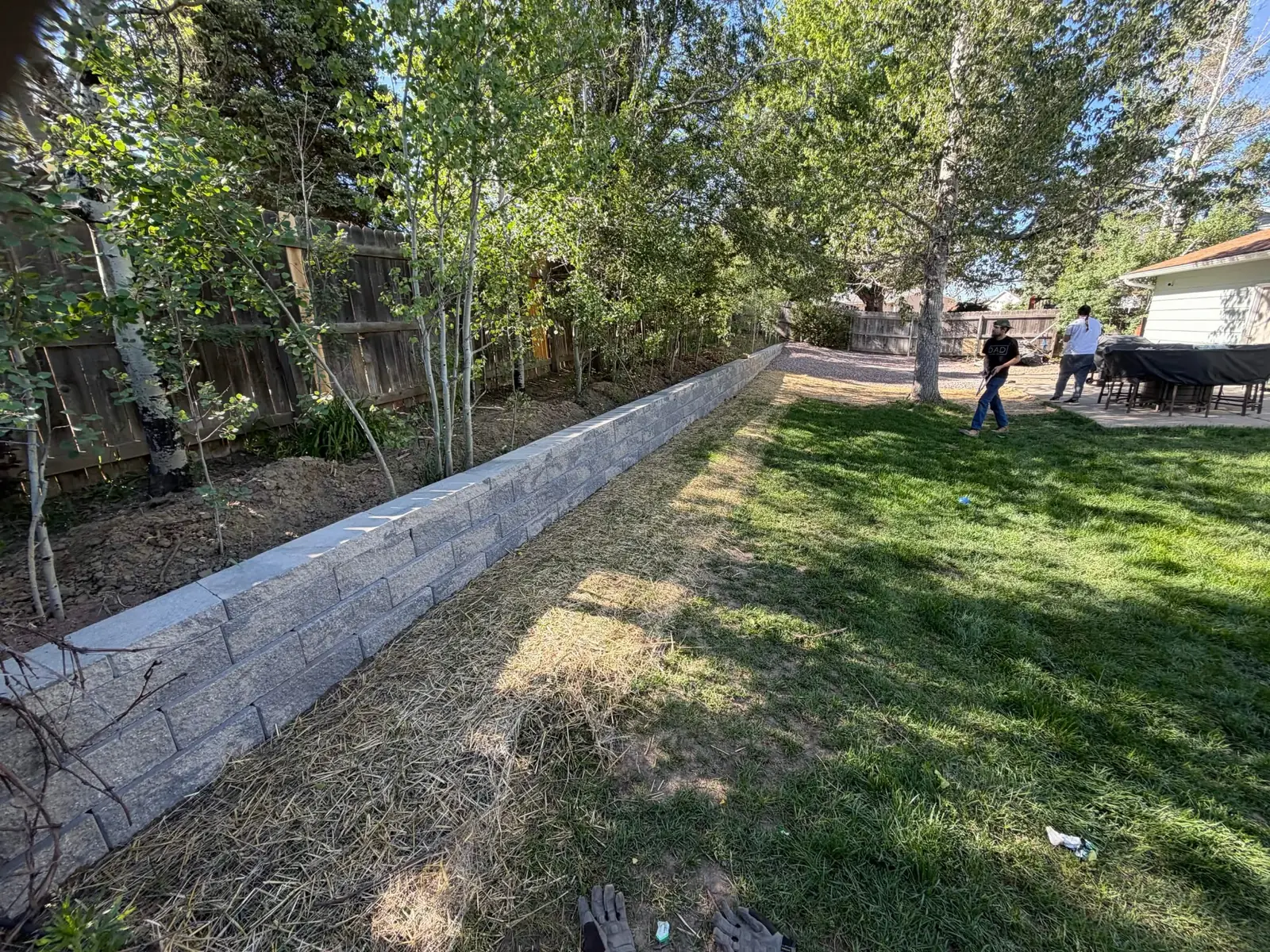 Long block retaining wall bordering a residential backyard