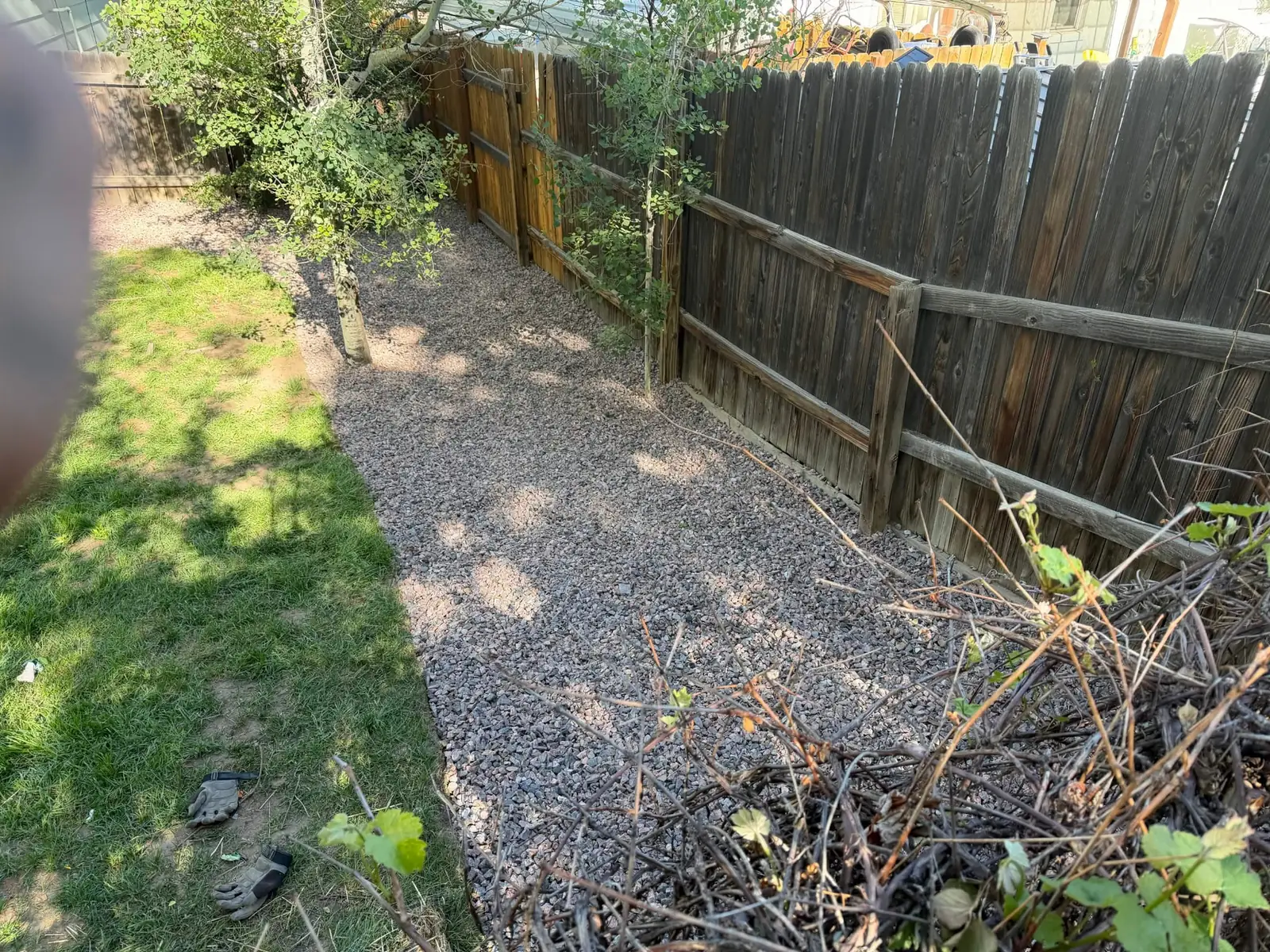 Low-maintenance decorative rock installed along a backyard fence line